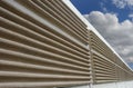 A modern soundproof wall with cloudy sky in background